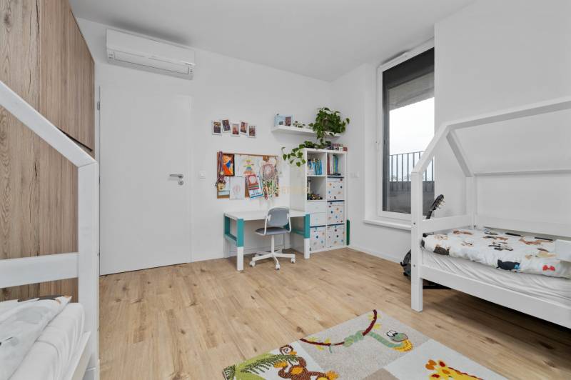 Children's room with a desk, bed, and floor with wooden decor in a 3-room apartment.