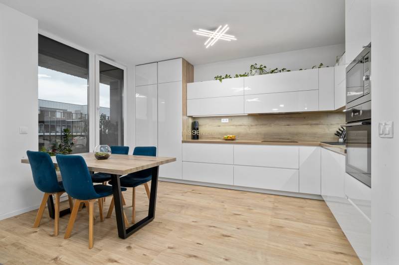 Kitchen corner with dining table in a 3-room apartment, floor with wooden decor.