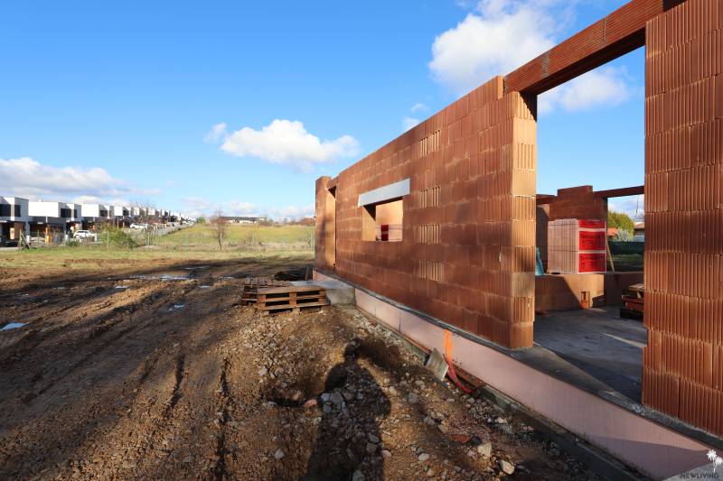 An unfinished family house on Drieňová Street in Nitra with a brick construction and building materials.