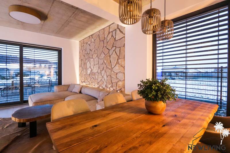 Interior of a family house with a stone wall, comfortable sofa, and wooden decor flooring.