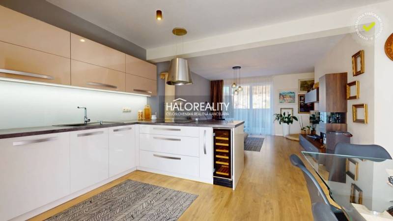 Kitchen with dining area, modern equipment, wooden floor, light red cabinets, family house.