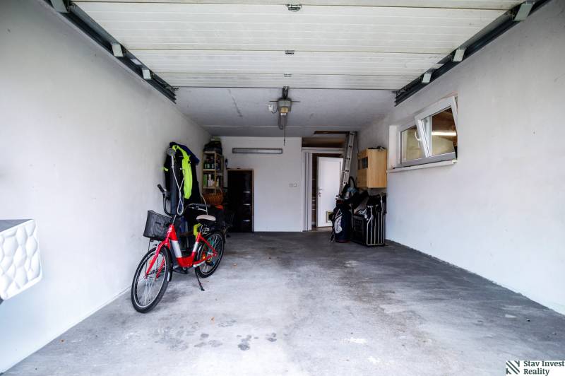 A garage in a family house with a bicycle and open doors, suitable for storage.
