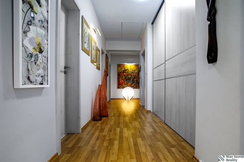 A hallway of a family house with decorative art and a wooden decor floor.