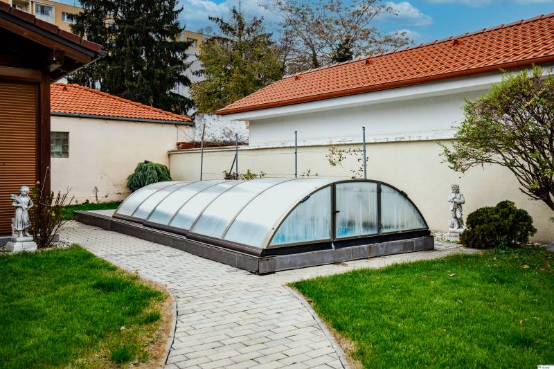 A swimming pool with a cover in the garden of a family house on Školská Street in Senec.