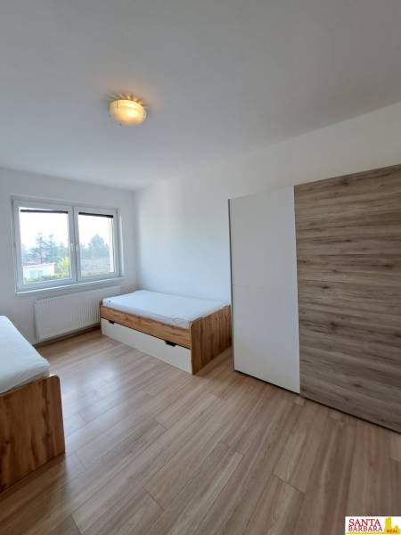 A room in a 4-room apartment with two beds and a floor with a wooden decor.