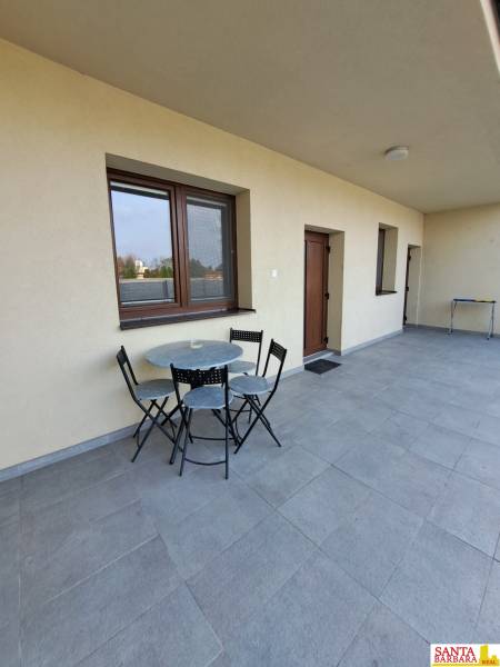 A terrace with seating in a 4-room apartment with a tiled floor and light walls.