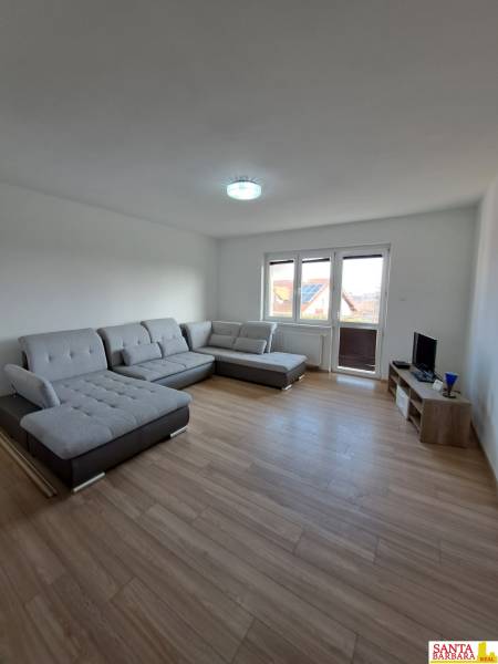 Living room in a 4-room apartment with a comfortable gray sofa and a floor with a wooden decor.