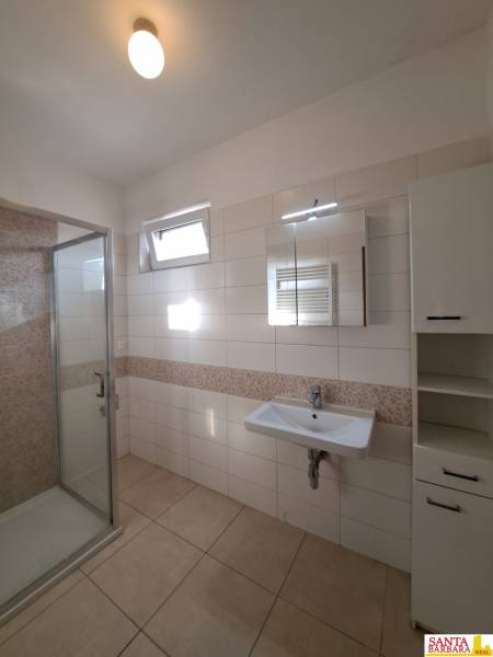 Bathroom with a shower, sink, and tiles in a 4-room apartment.