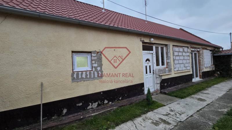 A family house on Hlavná Street in Veľká Mača with a red roof and an unfinished facade.