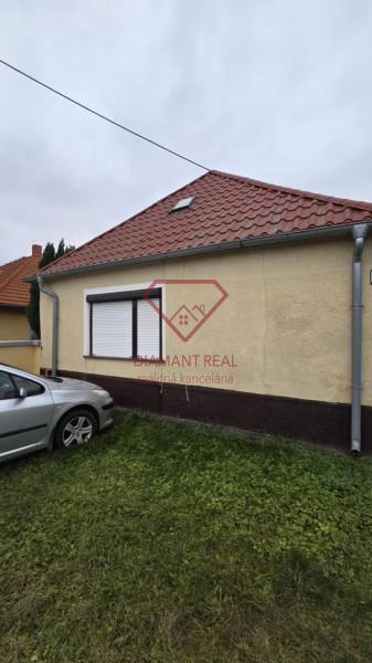 A family house on Hlavná Street in Veľká Mača with a car on the lawn.