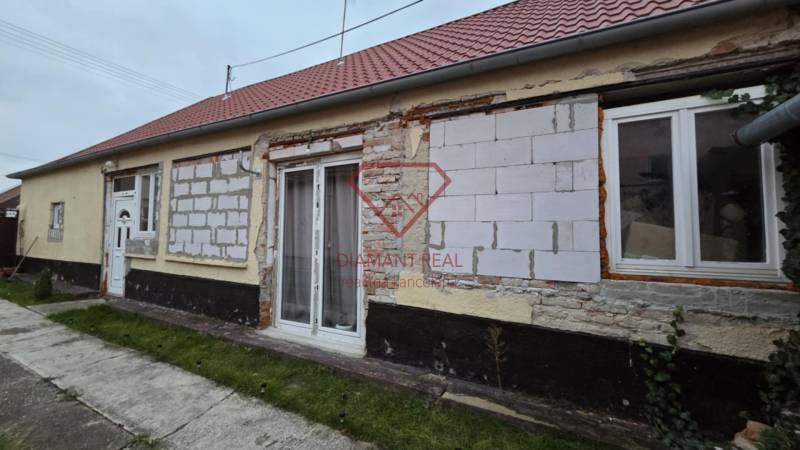 A family house on Hlavná Street in Veľká Mača with an unfinished facade and a red roof.