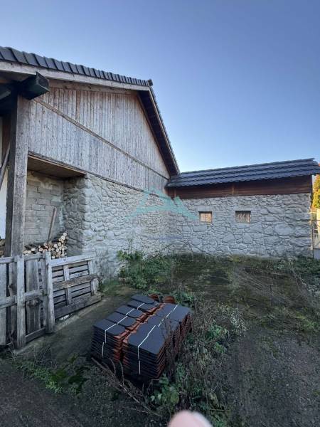 A family house in Demandice with a stack of roofing tiles and wooden structural elements.