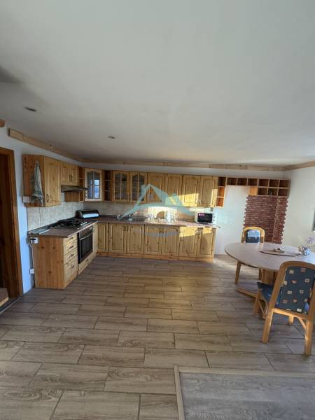 A country-style kitchen with wood-patterned flooring in a family house.