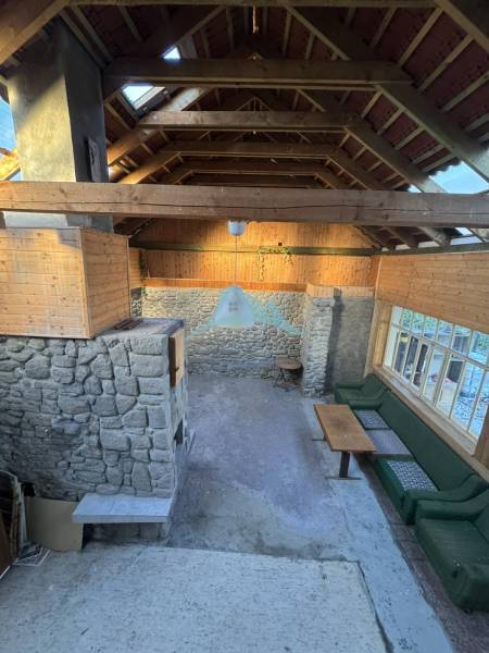 Stone walls, wooden ceiling, and seating in a family house.