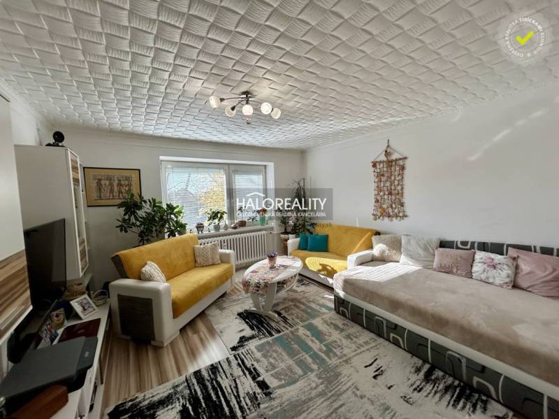 Living room in a two-room apartment with a wooden decor floor and comfortable seating.
