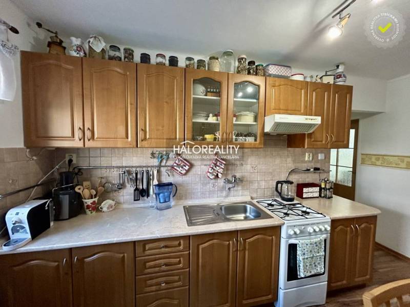 Kitchen in a 2-room apartment with wood decor on the floor and wooden cabinets.