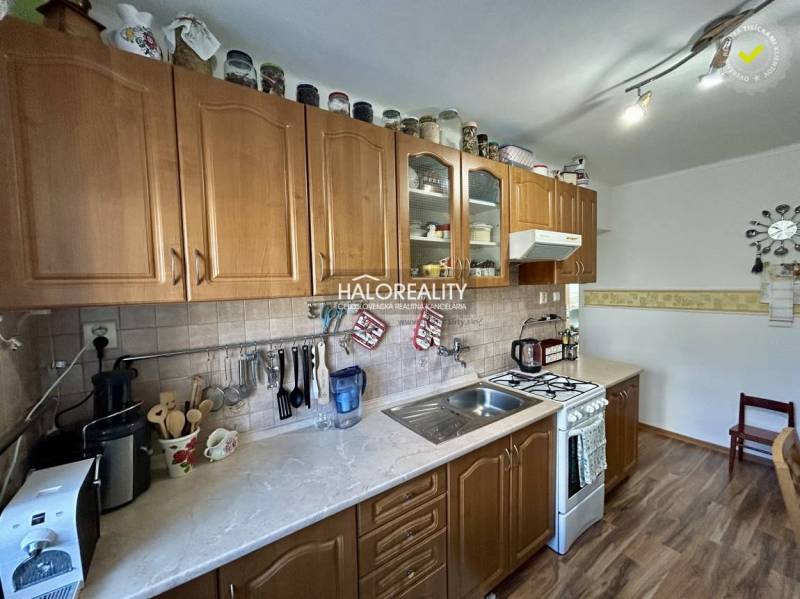 A kitchen with cabinets in a 2-room apartment with a wood-patterned floor.