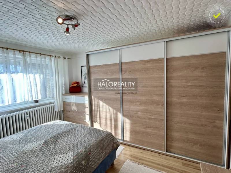 Bedroom in a 2-room apartment with wood-patterned flooring and a large built-in wardrobe.