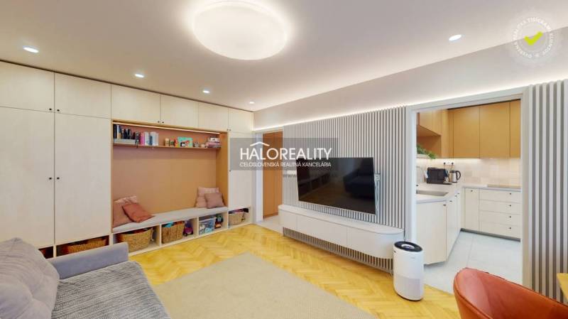 Living room in a three-room apartment with a wooden decor floor and built-in storage space.