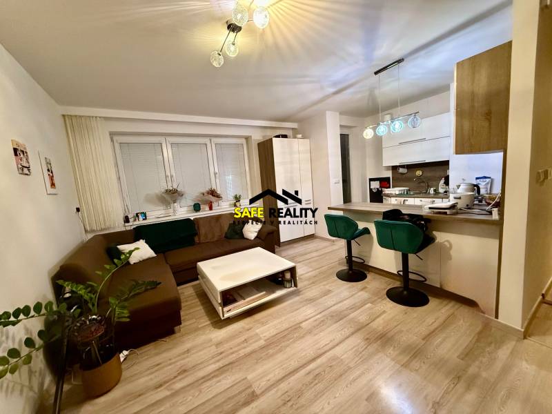 Living room and kitchen in a 2-room apartment with a wooden decor floor.