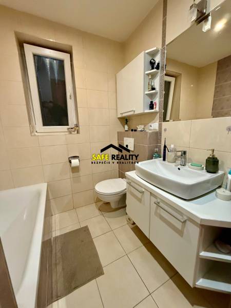 A bathroom with a bathtub and a white sink in a 2-room apartment.