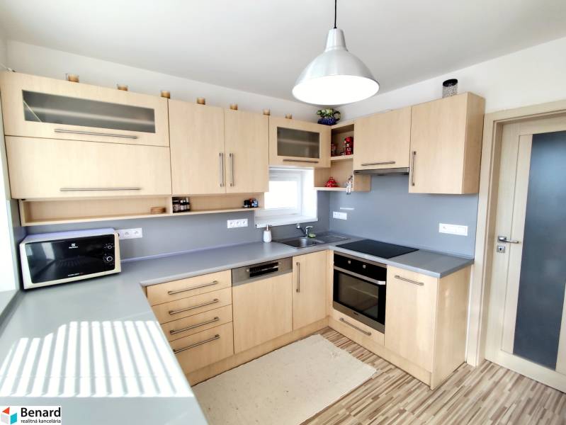A kitchen in a family house with a wooden decor and a gray countertop.