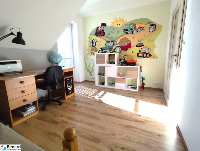 Children's room in a family house with a wooden decor floor and a cheerful wall mural.