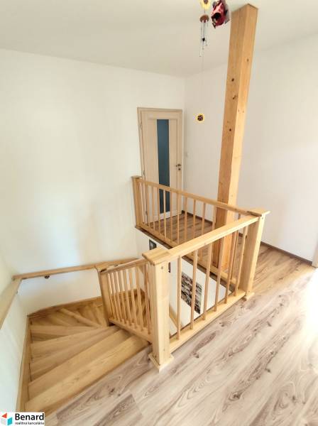 Inside the family house, there are wooden stairs and a floor with a wooden decor.