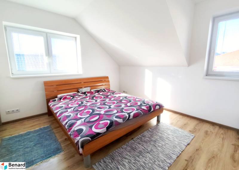 Bedroom with a bed and wooden decor flooring in a family house.