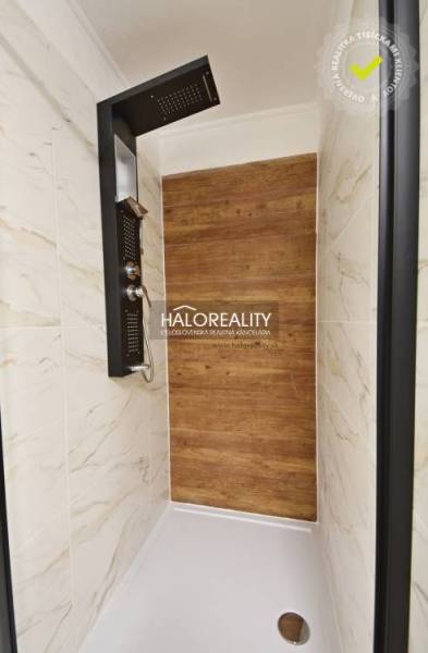 Shower corner with a wooden decor floor and marble tiles in a family house.