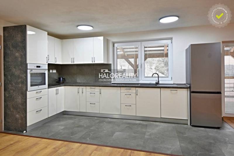 A kitchen in a family house with modern appliances and a wooden decor floor.