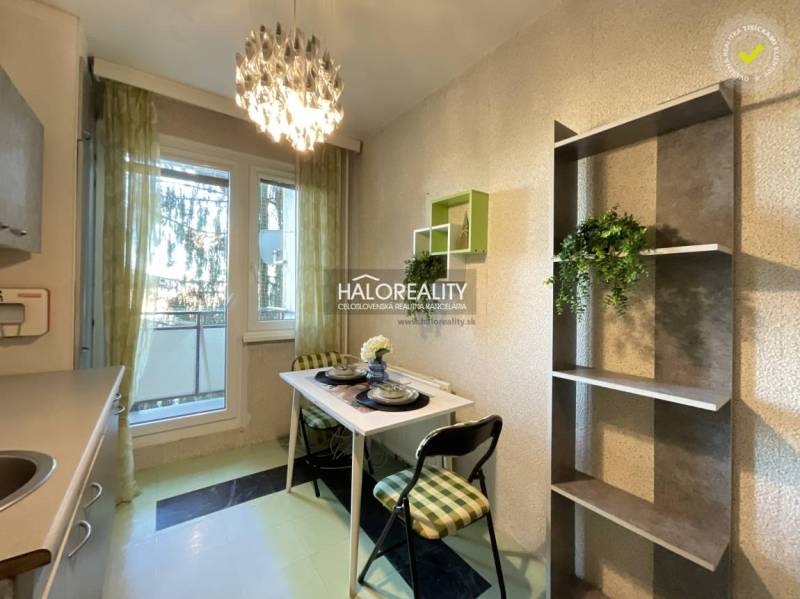 Dining area with a small table and chairs in a 3-room apartment.