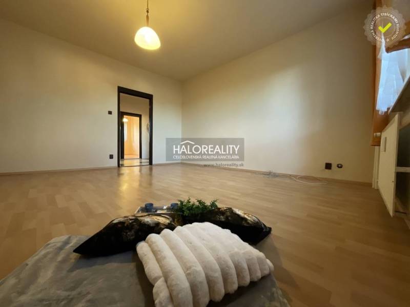 A room with a wooden decor floor in a 3-room apartment, lighting, light-colored walls.
