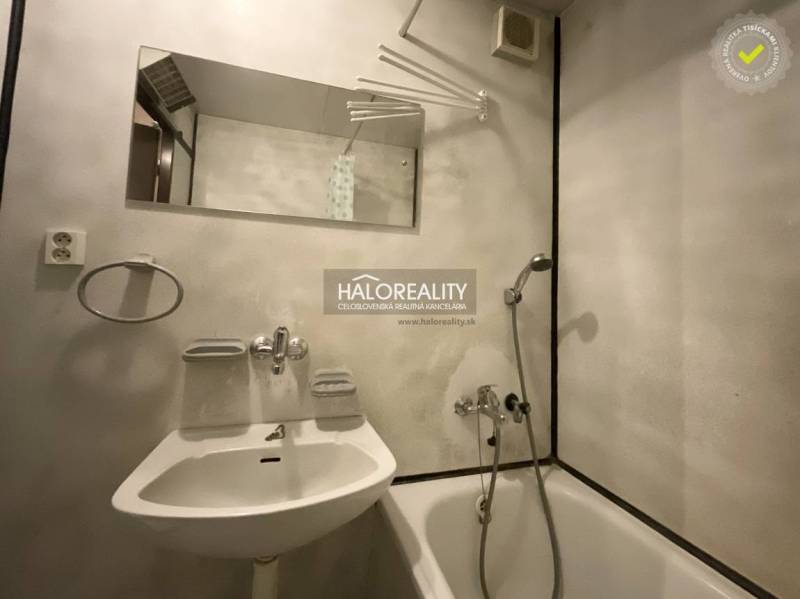 Bathroom in a 3-room apartment with a bathtub, mirror, and white sink.