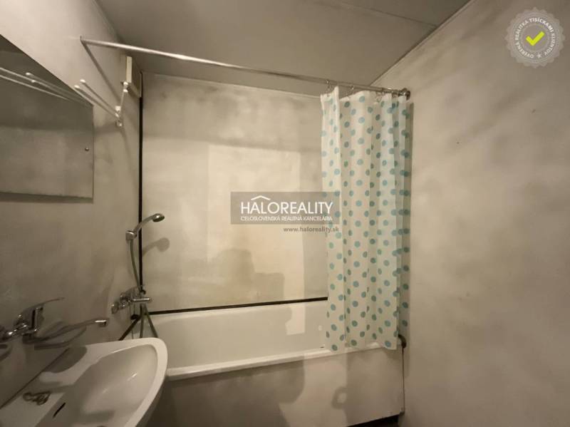 A bathroom in a 3-room apartment with a bathtub and a curtain with blue dots.