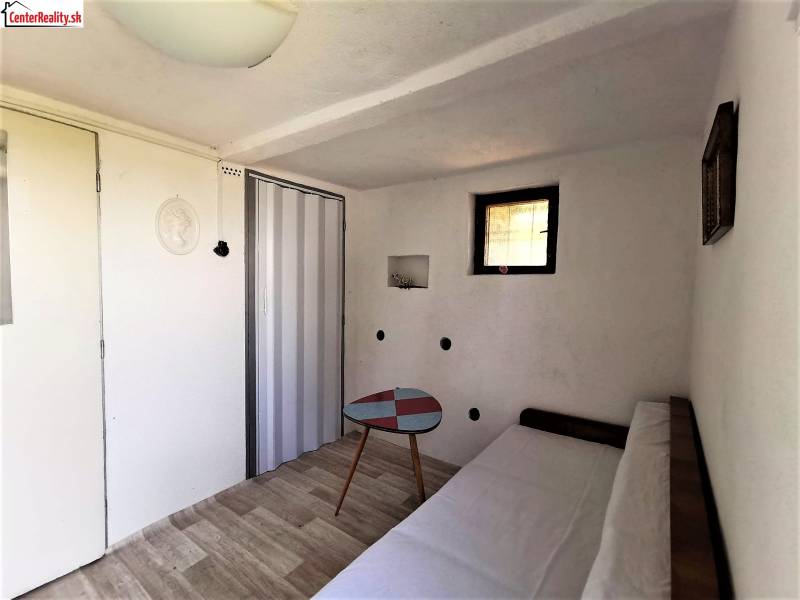 The cabin features a cozy room with a couch, a table, and wooden flooring.