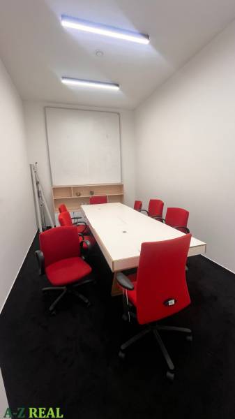 Offices with a white desk, red office chairs, and a black carpet.