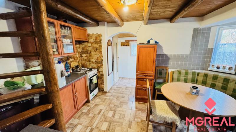 Rustic kitchen in a cottage with wooden floor decor and wooden ceiling.