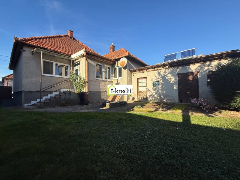 A family house in Machulince with a garden and an annex, on a sunny day with a blue sky.