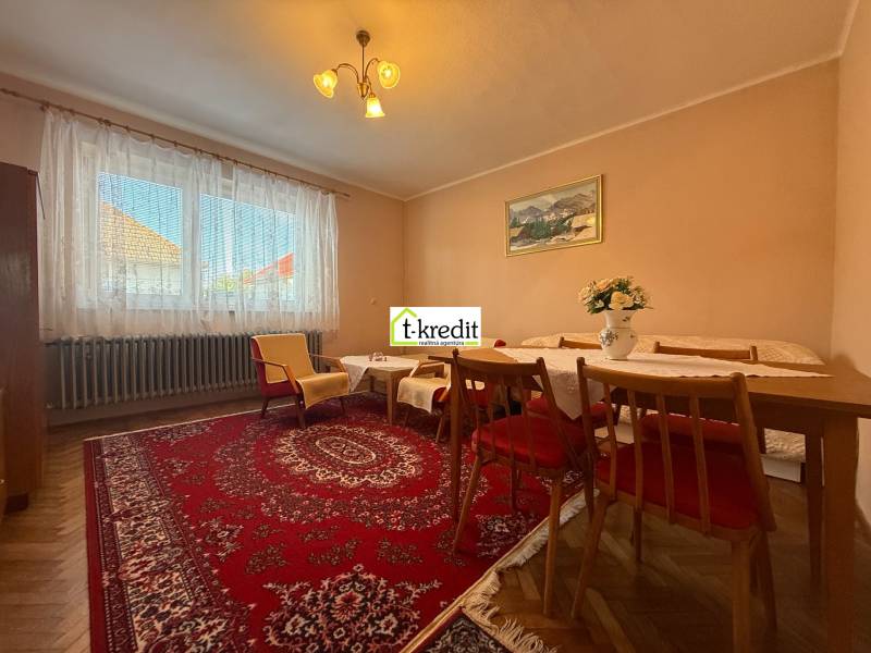 Living room in a family house with a carpet, wooden furniture, and a floor with a wood decor.