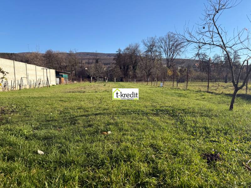 A grassy plot near a family house in Machulince with a view of the surrounding countryside.