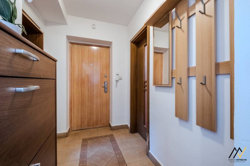 Entrance hallway in a 2-room apartment with tiles and coat hooks.