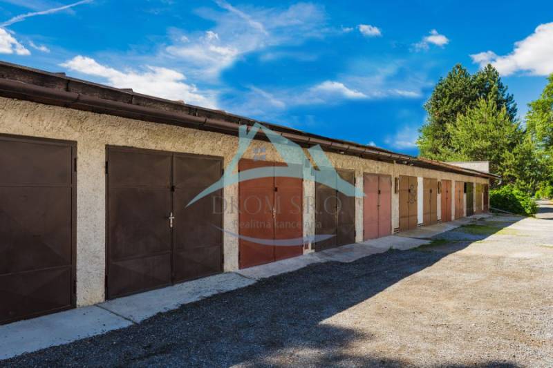 In a row, on Pálovická Street, stand garages with metal doors.