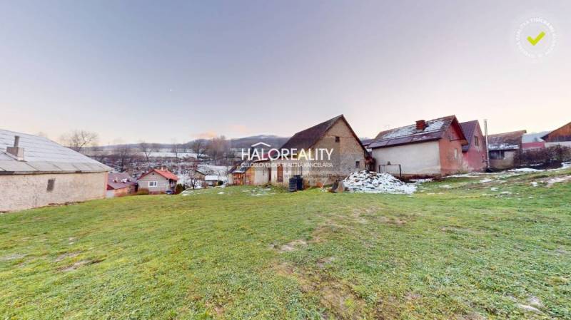 A family house in Klenovec surrounded by greenery, with a snowy landscape in the background.