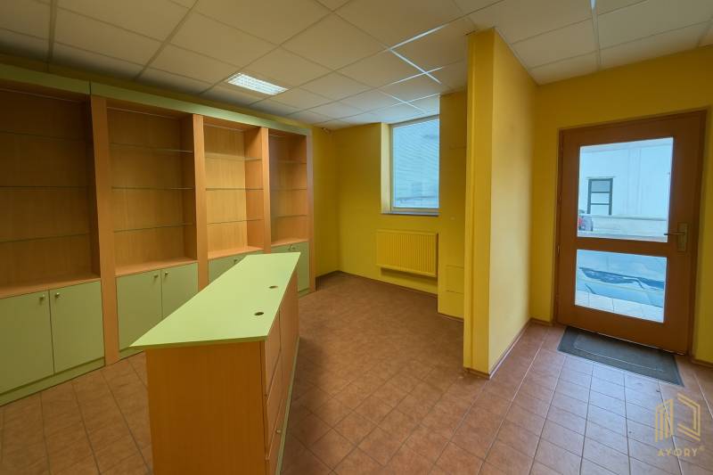 Commercial space with shelves, a counter, and tiling, ideal for various business purposes.