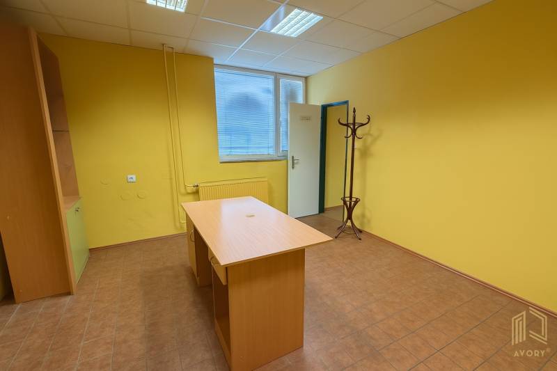 Yellow walls of the office with wooden furniture, floor with wooden decor, coat rack.