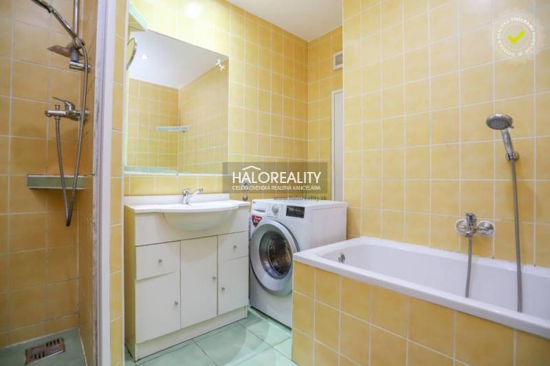 Bathroom with shower, bathtub, and washing machine in a 2-room apartment with tiles.