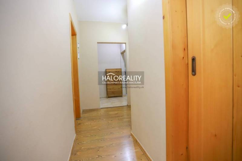 A hallway in a 2-room apartment with a wooden decor floor and built-in cabinets.