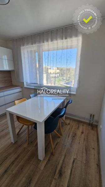 Dining area with a window in a 2-room apartment and a floor with a wooden decor.