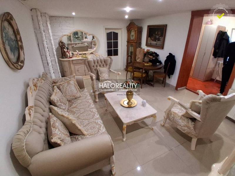 Living room with elegant furniture, a mirror, and a clock in a family house.